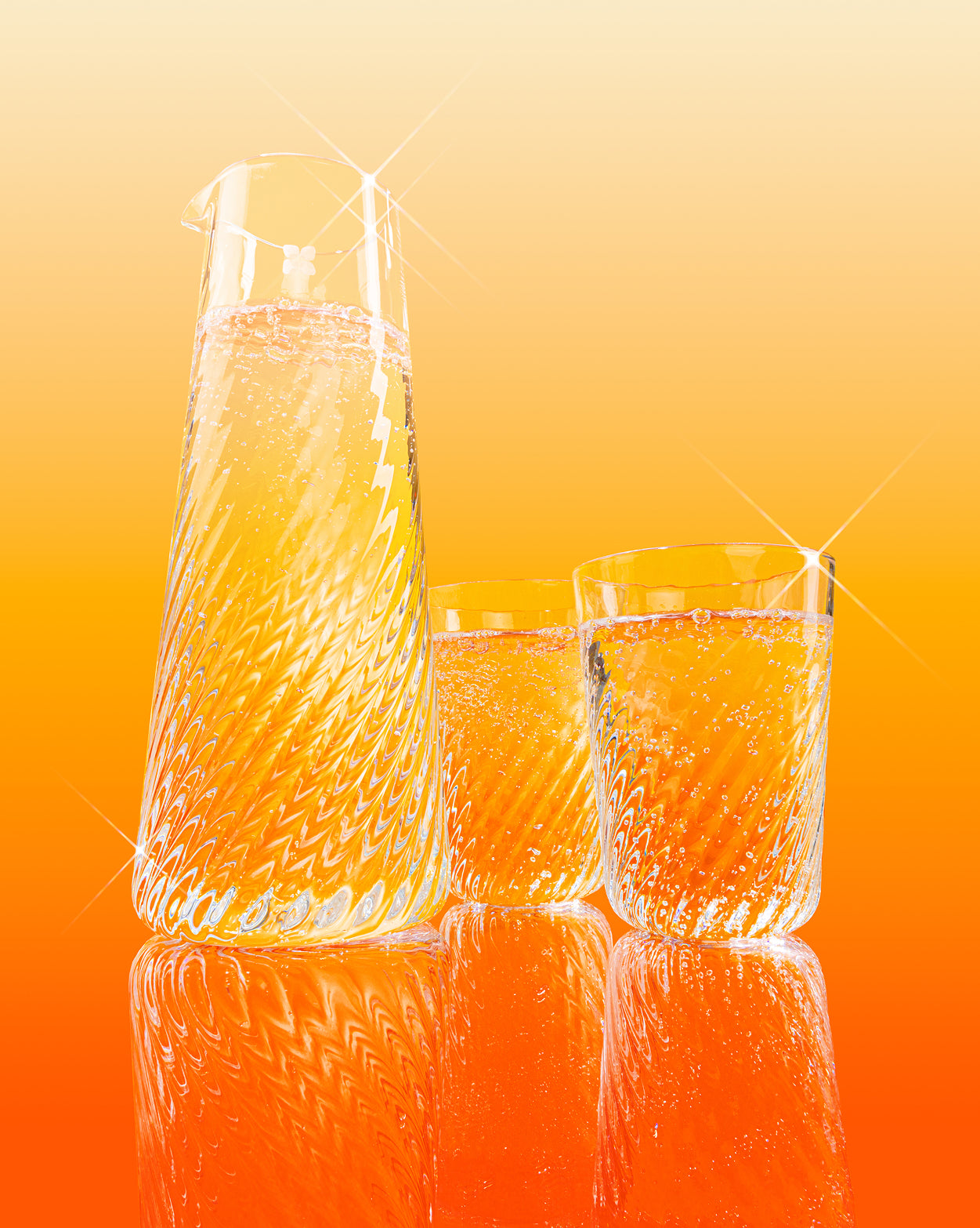Rippled Glasses set with fizzy amber-orange drink.