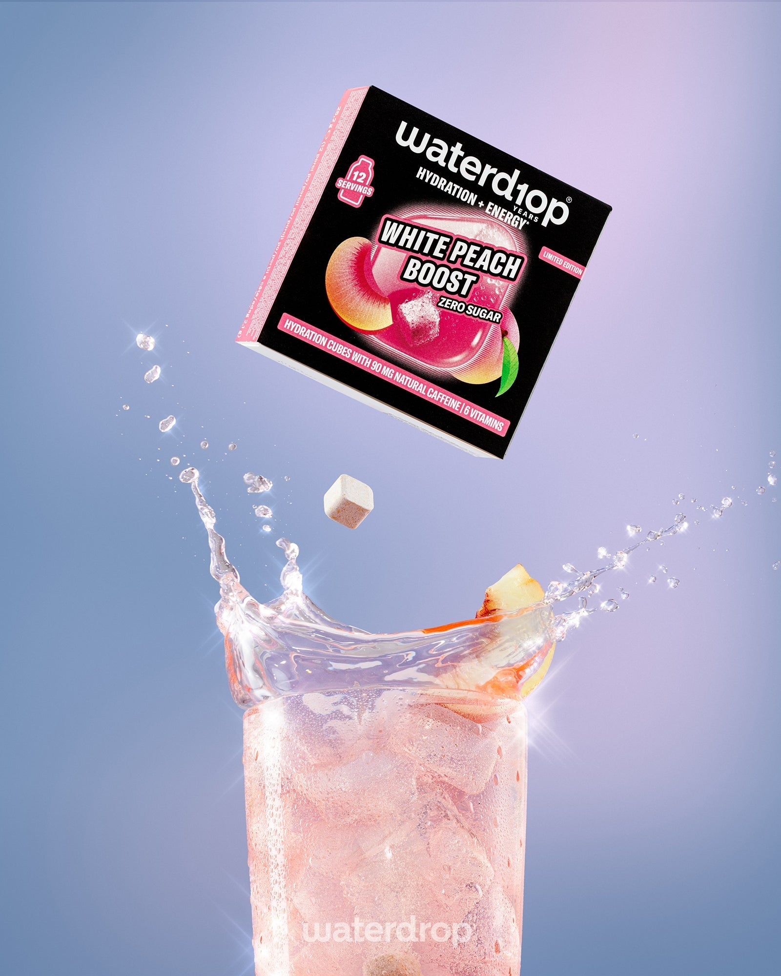 Kutija napitka White Peach Boost iznad visokog čaša s ružičastim napitkom i ledom.