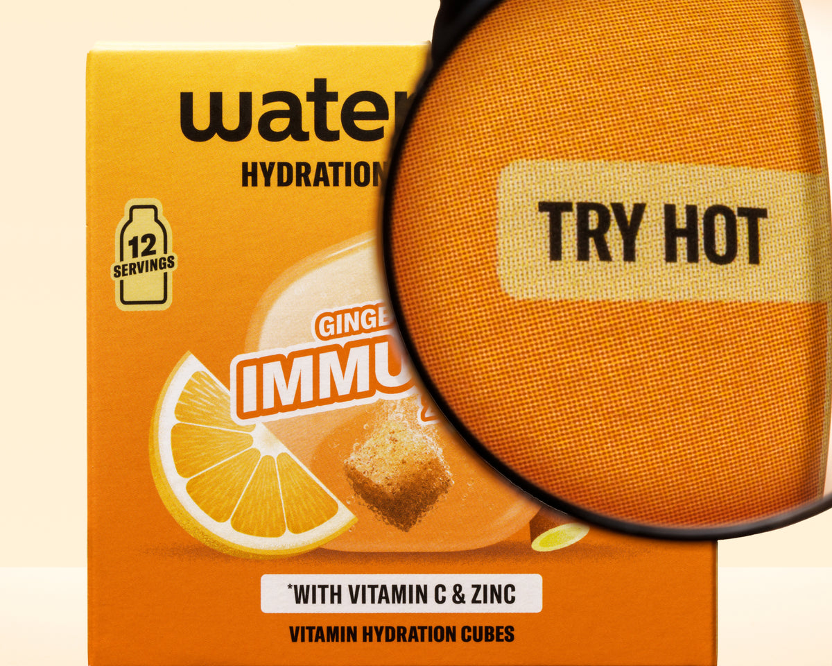 Narančasta kutija s grafikom limuna i povećalom preko nje, promiče kocke za hidrataciju s vitaminom C i cinkom.